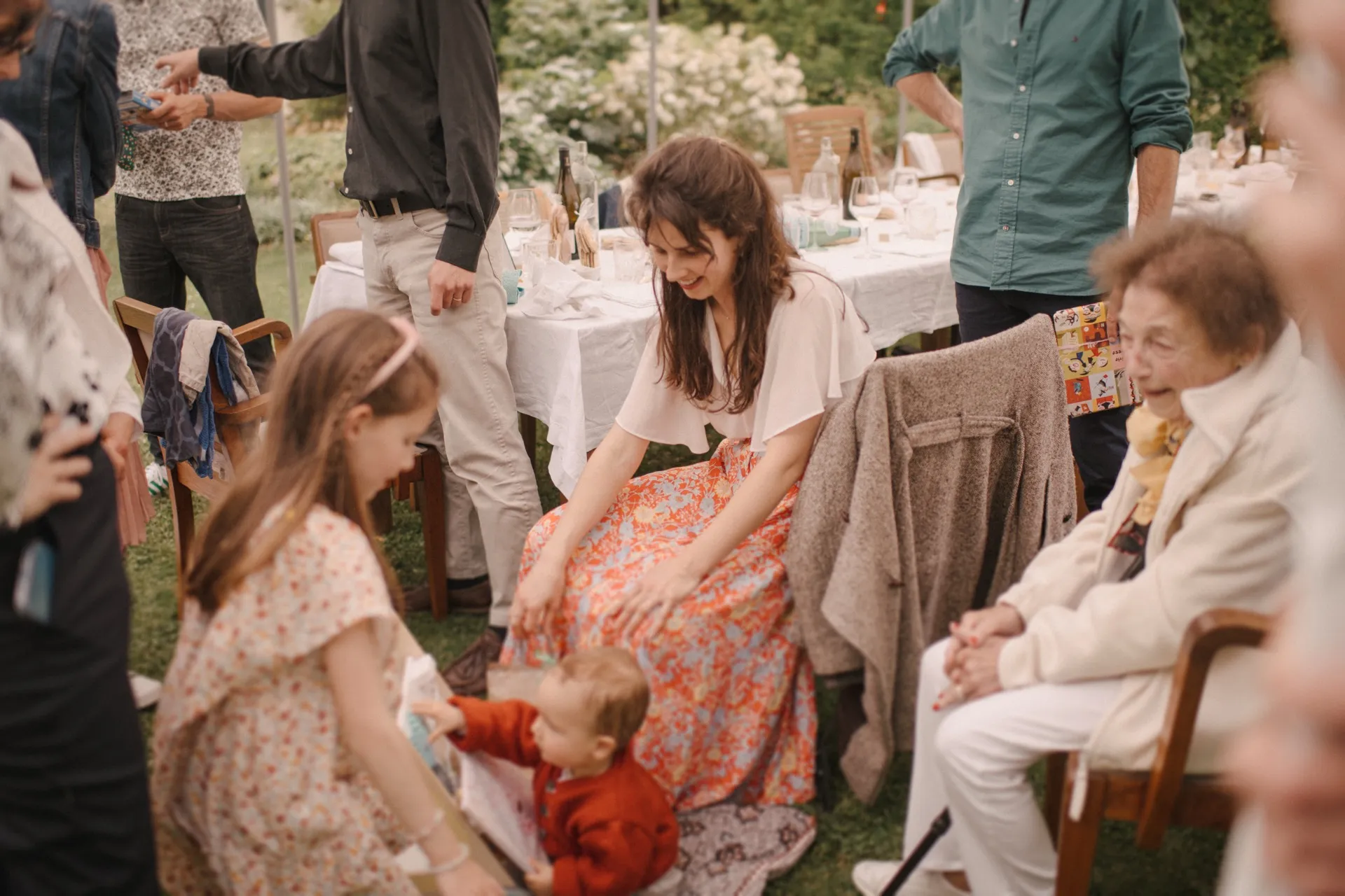 Moment de fête en famille dans un jardin, entre générations et jeux partagés
