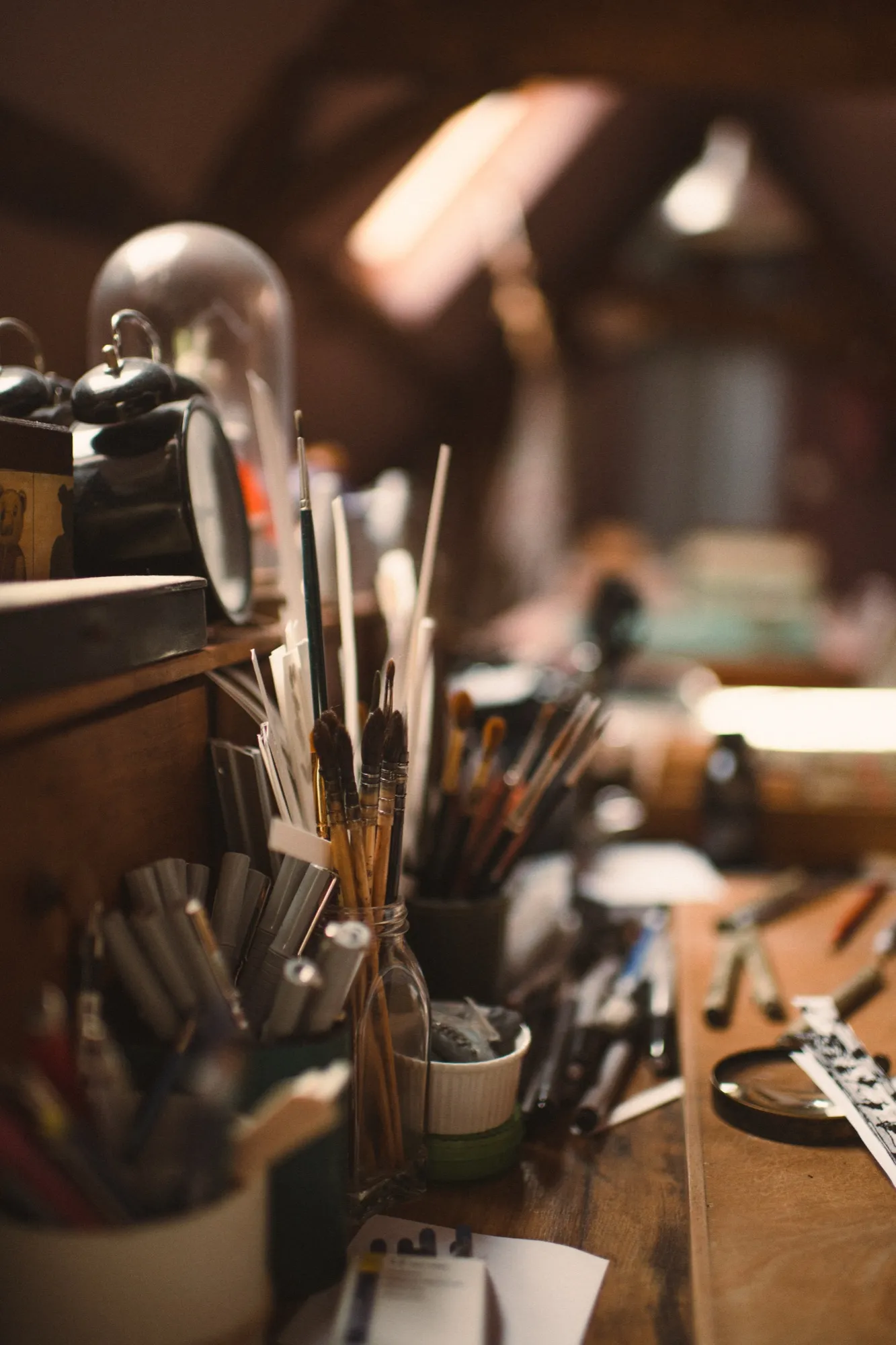Atelier d’artisan avec pinceaux, matières et outils sur un bureau chaleureux